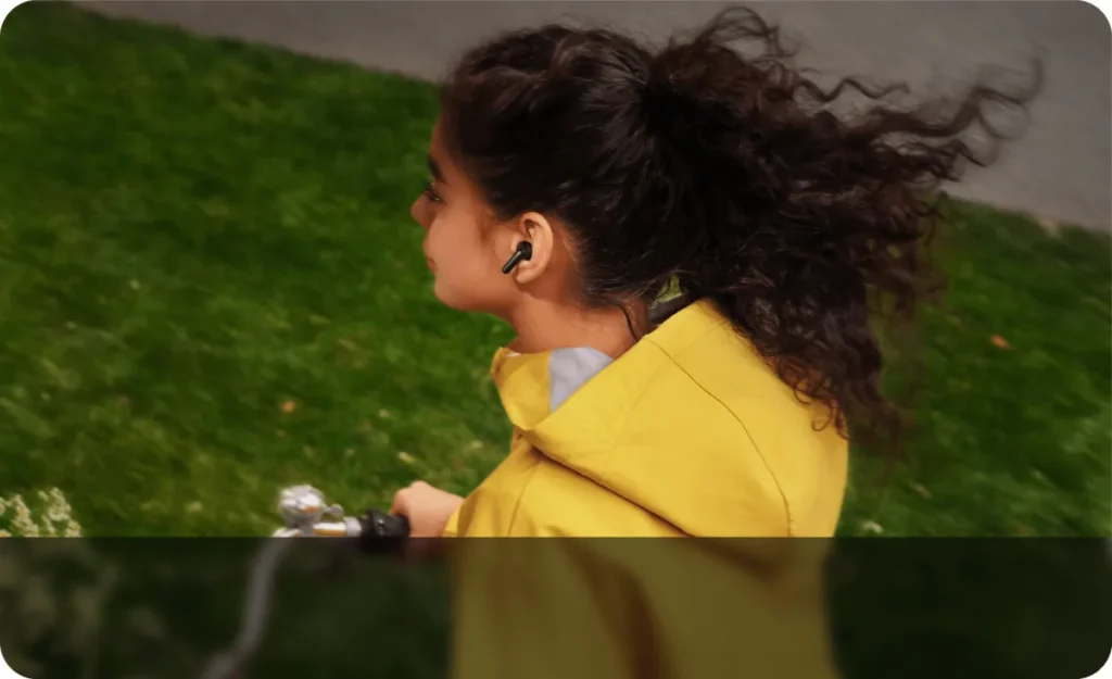 Γυναίκα με ακουστικά REDMI Buds 8 Active σε εξωτερικό χώρο