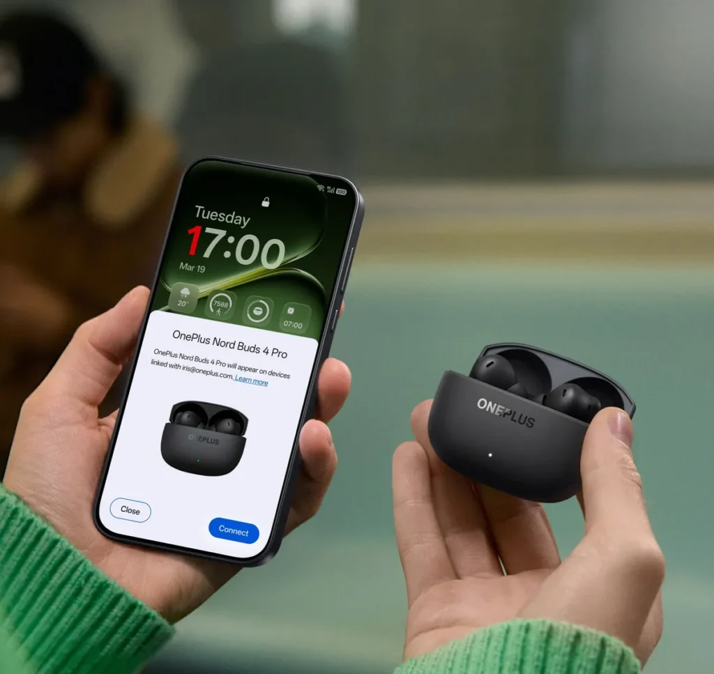 Χέρι κρατά θήκη OnePlus Nord Buds 4 Pro σε μαύρο και κινητό για σύζευξη